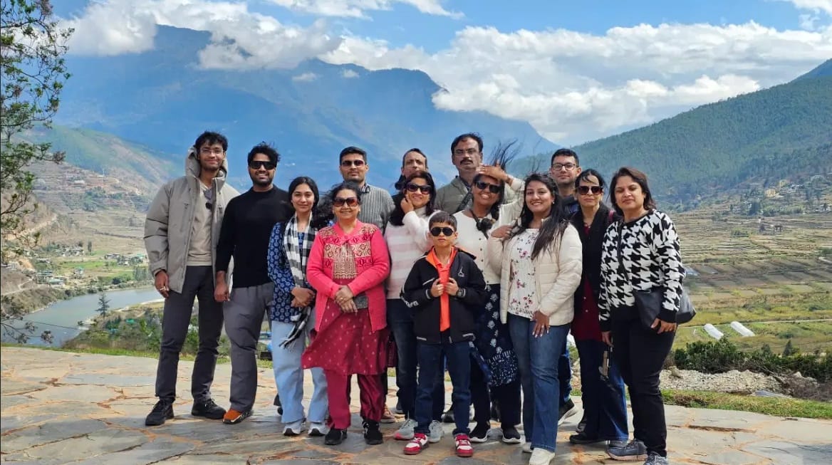 Travellers taking a group photo at a scenic viewpoint during a Bhutan trip.