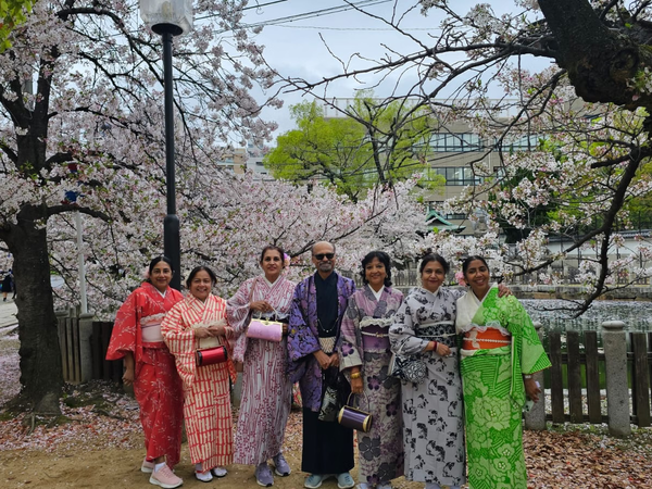 School friends in kimonos under Osaka cherry blossoms